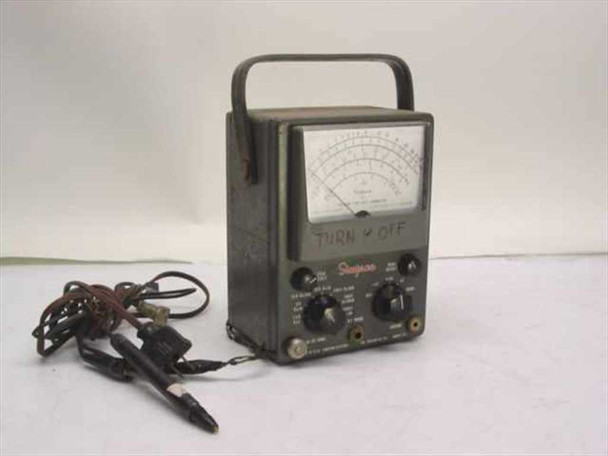 Simpson 311 Vacuum Tube Volt-Ohmmeter front 3/4 view showing analog meter face, carry handle, rotary controls, and attached test leads