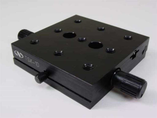 Newport TSX-1D dovetail linear stage – 3/4 angled top view showing black anodized aluminum platform with threaded mounting holes, dual adjustment knobs, and TSX-1D model label