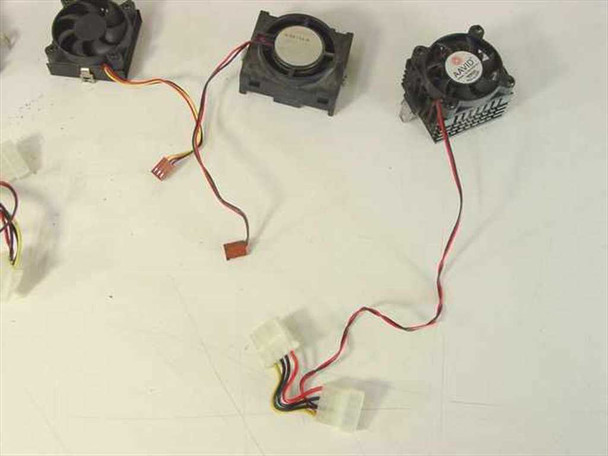Close-up of three CPU cooling fans — plain black fan, taller blower-style fan, and fan with heatsink fins — each with red-and-black 2-pin or Molex power leads