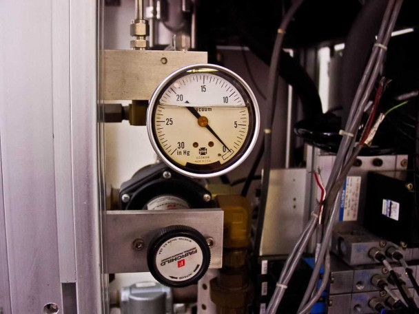 Vacuum pressure gauge reading approximately 0–30 in Hg range with Fairchild regulator below it – mounted in pneumatic bay
