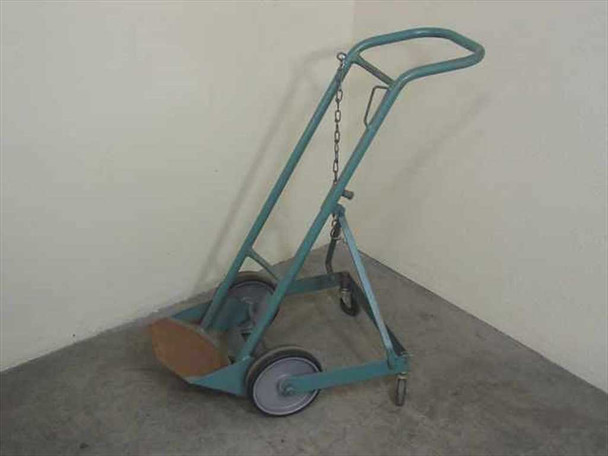 Blue gas cylinder hand truck — three-quarter side view showing full frame profile, two main wheels, rear stabilizer, and hanging safety chain
