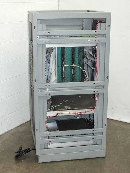 Advanced Microtechnology burn-in system rear view showing open rack chassis with wiring harness, green backplane, and power cabling