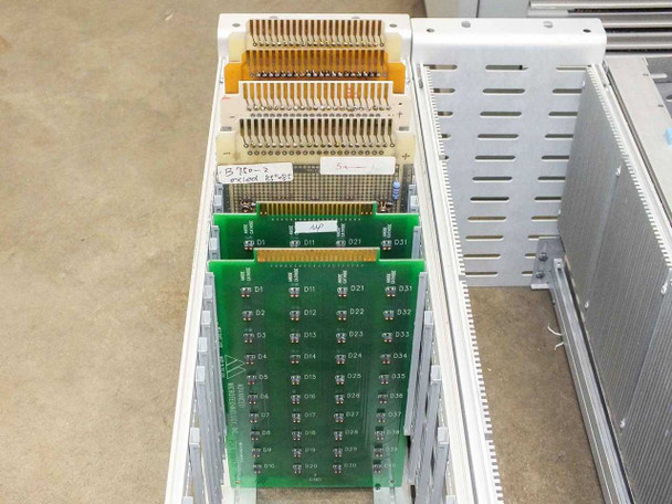 Close-up of Advanced Microtechnology plug-in burn-in boards stacked in card tray showing gold-edge connectors and green PCB matrix layout