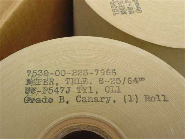Close-up of teletype paper roll label showing NSN 7530-00-223-7966, PAPER TELE 8-25/64, spec UU-P547J TY1 CL1, Grade B Canary
