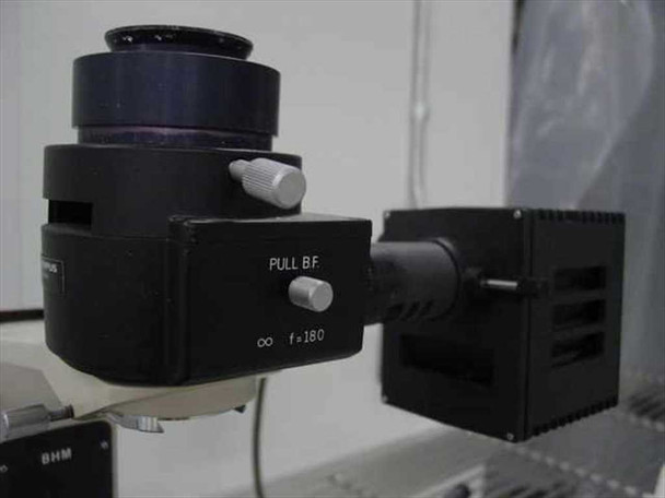 Close-up of Olympus BHM optical head — shows PULL BF selector, infinity f=180 specification, and lamp housing port