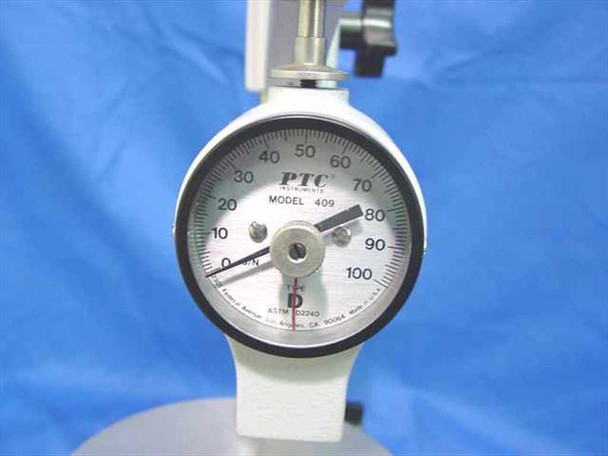PTC Model 409 durometer dial face — 0–100 Shore D scale, ASTM D2240, indenter tip visible