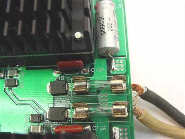 Close-up of DB48-24S-2 PCB corner showing Sprague 30D capacitor, SMD components, fuse holders, and output wire leads