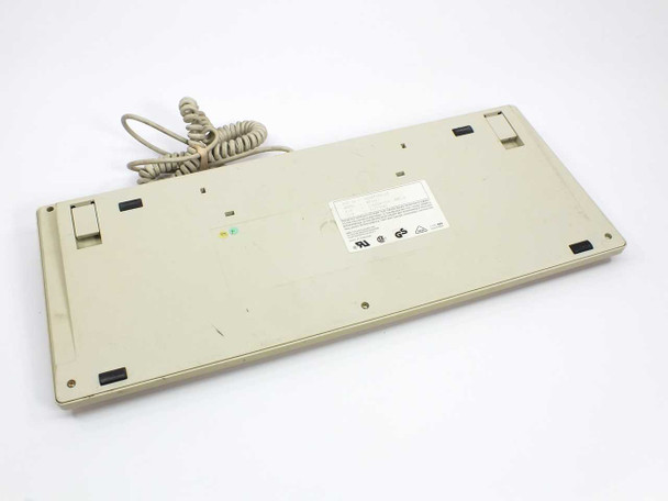DEC RT101+ keyboard bottom view showing label, four corner feet, folded tilt legs, and coiled cable