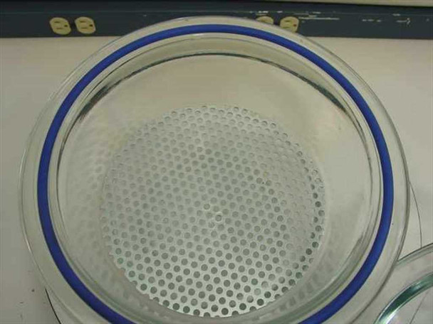 Top-down view inside Wheaton desiccator glass bowl showing circular perforated metal shelf insert resting on ledge with blue rubber gasket visible at rim