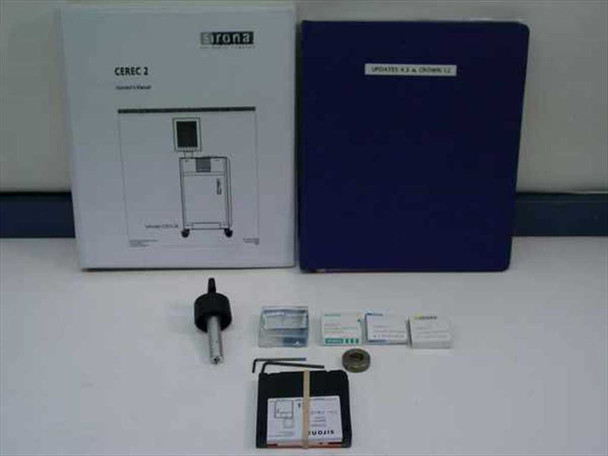 Sirona Cerec II included accessories laid out: Cerec 2 operator's manual, Updates binder, milling spindle tool, diamond cylinder burs in boxes, hex keys, calibration wheel, and software floppy disk