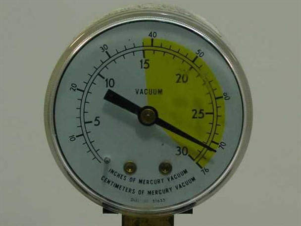 Close-up of vacuum gauge on Edwards E2M-1 pump — dial reads in inches of mercury vacuum and centimeters of mercury vacuum, needle indicates partial vacuum