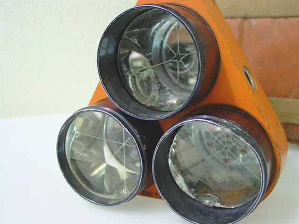 Retro-Ray triple prism reflectors — close-up of three corner-cube prisms showing internal cross-hair markings and light scratches on glass faces