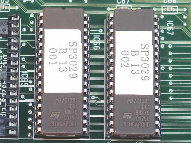 Close-up of two STMicroelectronics M27C1001 EPROM chips on the NEC SPA-24PRTBA-B PCB, labeled SP3029 B 13 001 and SP3029 B 13 002