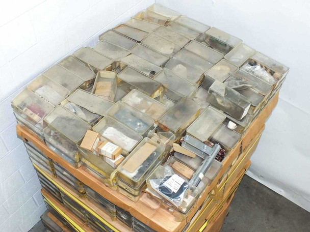 Overhead view of pallet top layer showing dozens of sealed plastic parts bins with mixed vintage film camera hardware