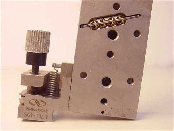 Newport 561-Tilt ULTRAlign stage stood on end – Newport 561-TILT label visible on base, spring-loaded tilt clamp with knurled knob, and brass ball-bearing preload row on face with multiple mounting holes