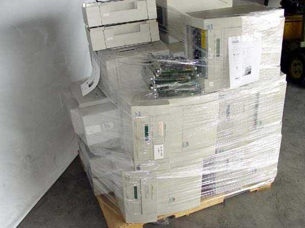 Tektronix Phaser printer lot — rear/side view of pallet showing stacked Phaser 350 units with internal boards and components visible through plastic wrap