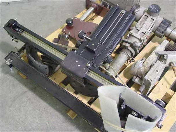 Top-down view of vintage industrial camera accessories — black anodized linear rail system, pan/tilt mechanism, motor drive assembly, and plastic bracket visible