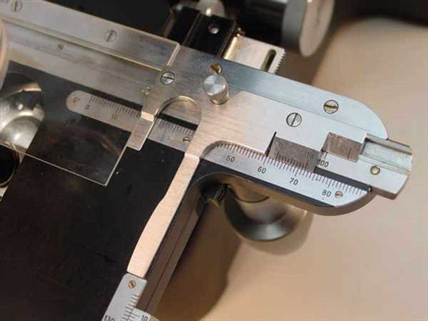 Leitz 561007 X-Y mechanical stage vernier scale close-up showing millimeter graduations at the 50–80mm range on one axis