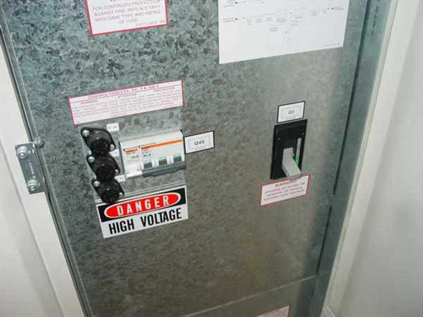 MGE EPS 2000 UPS interior door panel — circuit breakers labeled Q45, Q1 disconnect switch, and Danger High Voltage warning sticker