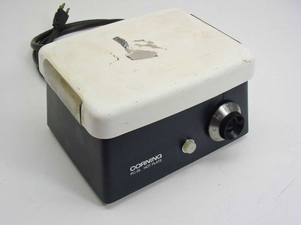 Corning PC-35 Laboratory Hot Plate front and right-side view showing ceramic top with peeling and chipping, dark gray housing, CORNING PC-35 HOT PLATE nameplate, temperature knob, and cycle indicator light