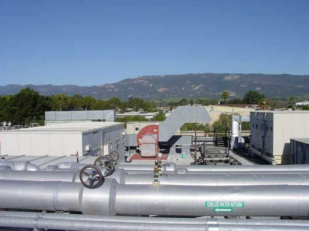 Rooftop HVAC overview showing multiple air handlers, insulated piping with chilled water return label and manual valves