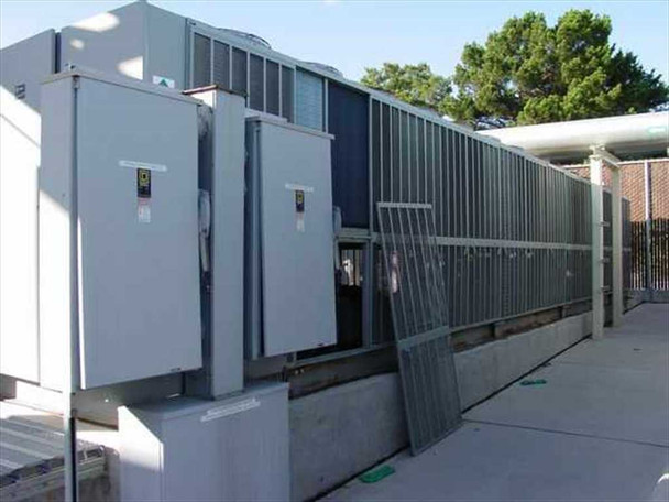 Trane RTAA400 chiller – three-quarter front view showing dual electrical cabinets, condenser fin section, and chilled water piping connections at rooftop installation