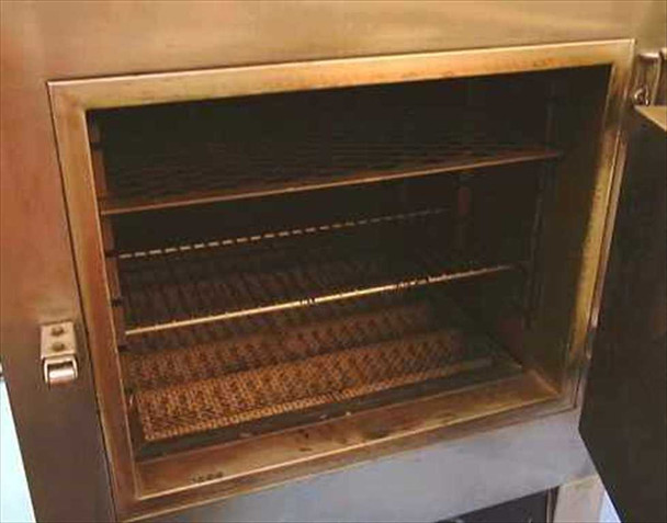 Blue M OV-185A oven interior view with door open showing two wire shelves and stainless chamber with some discoloration and heat marks on walls and floor