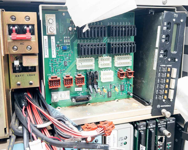 Motorola Microcite internal backplane/motherboard area showing green circuit board with multi-pin connectors, DB15 connector, and wiring harness alongside BATT LOAD terminal