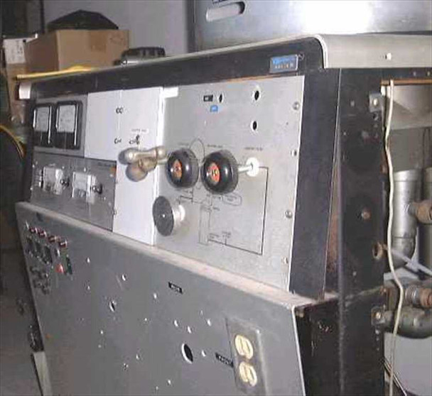 CHA-600 control panel close-up showing two analog meters, lever switch, dual large rotary controls with red indicator knobs, and circuit diagram label; panel shows heavy wear and aging