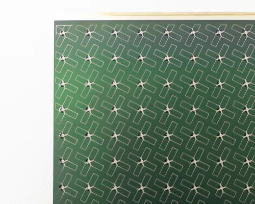 Close-up of Nanosolar NanoCell CIGS solar cell surface showing silver interconnect grid lines and small contact dots across green active area
