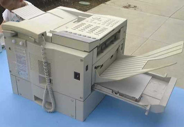 Canon Laser Class 5500 fax machine – left-side three-quarter view showing corded handset, rear panel, dual paper trays, and output tray extended