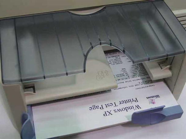 HP DeskJet 820Cse paper output tray close-up with a Windows XP Printer Test Page successfully printed and emerging