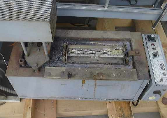 Technical Devices Mark I-C wave soldering machine – top-down view of solder pot section with cover removed, showing wave nozzle and heavy flux/solder residue buildup