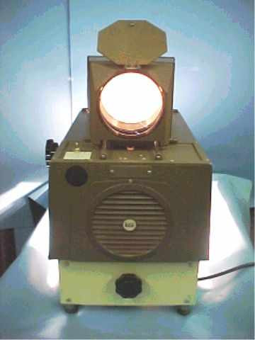 Buhl Mark IV Opaque Projector – front view with lamp illuminated, showing open top reflector housing, circular ventilation grille, and power cord