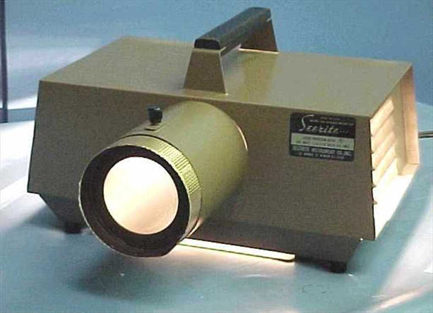 Testrite SeeRite opaque projector – front three-quarter view with lens illuminated, showing cooling vent louvers on right side and SeeRite Testrite Instrument Co. label