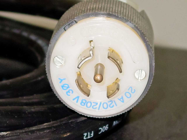 Close-up of locking power plug end showing 20A 120/208V 3-pole markings stamped in blue on white connector body
