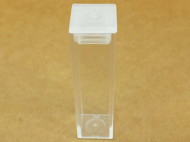Brandtech macro cuvette with stopper cap seated, front view showing clear polystyrene body and white cap