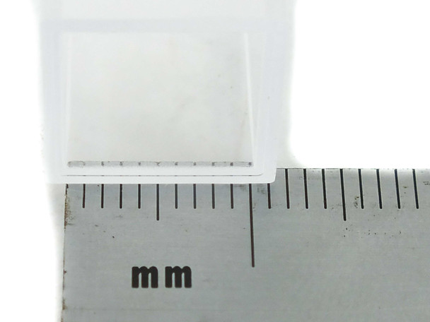 Close-up of Brandtech macro cuvette stopper cap next to metric ruler — cap aperture detail in millimeters