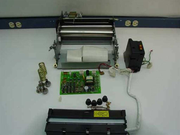 Dataproducts Jolt internal components laid out: roller/heater assembly, green PCB control board, black power module with wiring, and heater strip with hardware