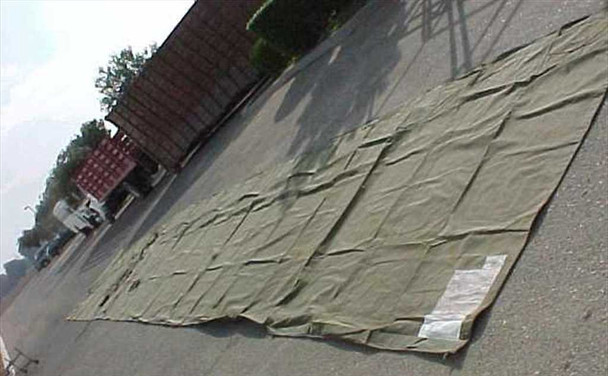 Camel Manufacturing M-1942 GP Large military tent wall section fully unrolled on pavement, showing full olive drab oiled duck canvas panel approximately 7.5 x 55 feet