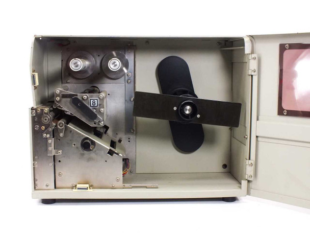SATO M-8400 interior view with access door open showing thermal transfer print mechanism, ribbon supply/take-up spools, and platen roller assembly
