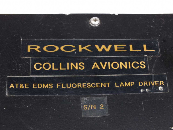 Rockwell Collins Avionics AT&E EDMS Fluorescent Lamp Driver – close-up of identification label plate reading 'Rockwell Collins Avionics' and 'AT&E EDMS Fluorescent Lamp Driver' with serial number S/N 2