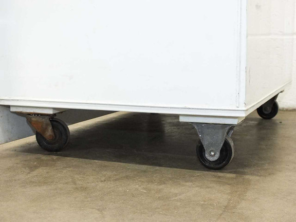 Close-up of caster wheel base – four swivel casters, one showing surface rust on wheel bracket