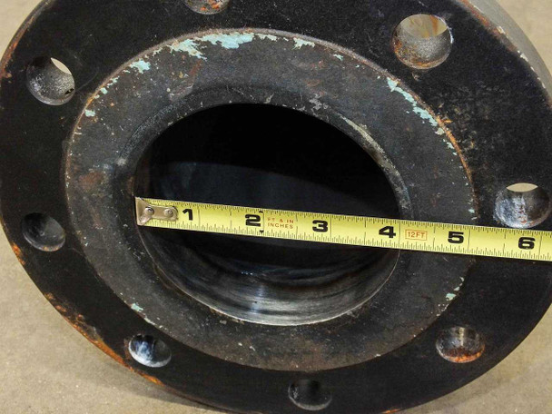 Close-up of socket weld raised face flange face showing bolt holes, raised face seating surface, and surface rust with tape measure showing approximately 4-inch bore