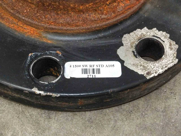 Flange label close-up reading 4 150# SW-RF STD A105 with barcode and lot number 2711 on sticker affixed to flange face