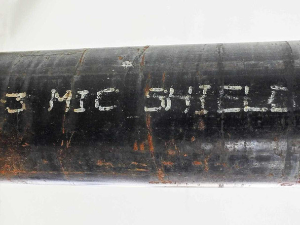 Close-up of pipe body showing painted MIC SHIELD lettering indicating factory-applied microbiologically influenced corrosion coating