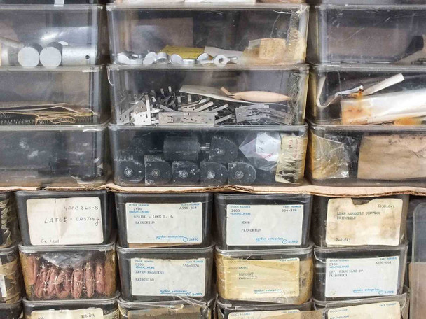 Close-up of bins showing Fairchild labels including latch casting and various small parts with Gordon Enterprises supply labels