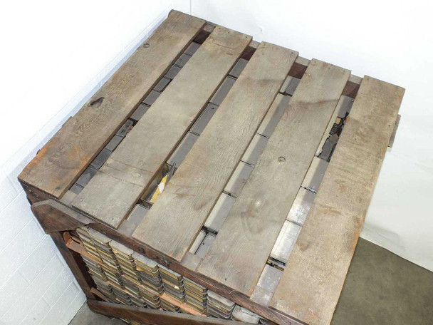 Top view of the wooden pallet crate showing slatted wood lid construction with metal strap reinforcement and partial view of parts bins visible beneath