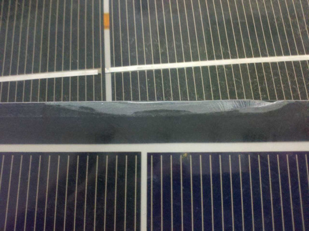Close-up of Solopower SFX1-35 panel surface showing lifting and peeling of the clear backing layer between cell rows