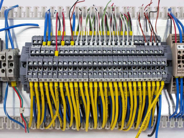 Close-up of Weidmuller WDK 2.5 ZQV double-stack terminal blocks with yellow jumper wires installed